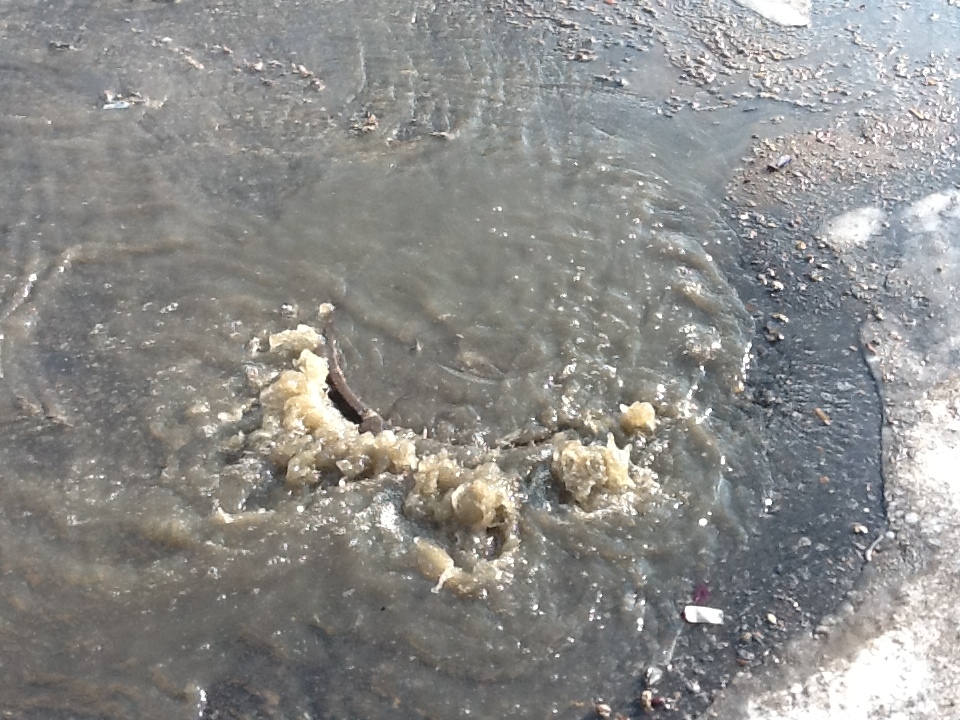 Грязная и дурнопахнущая вода хлещет из канализационного люка